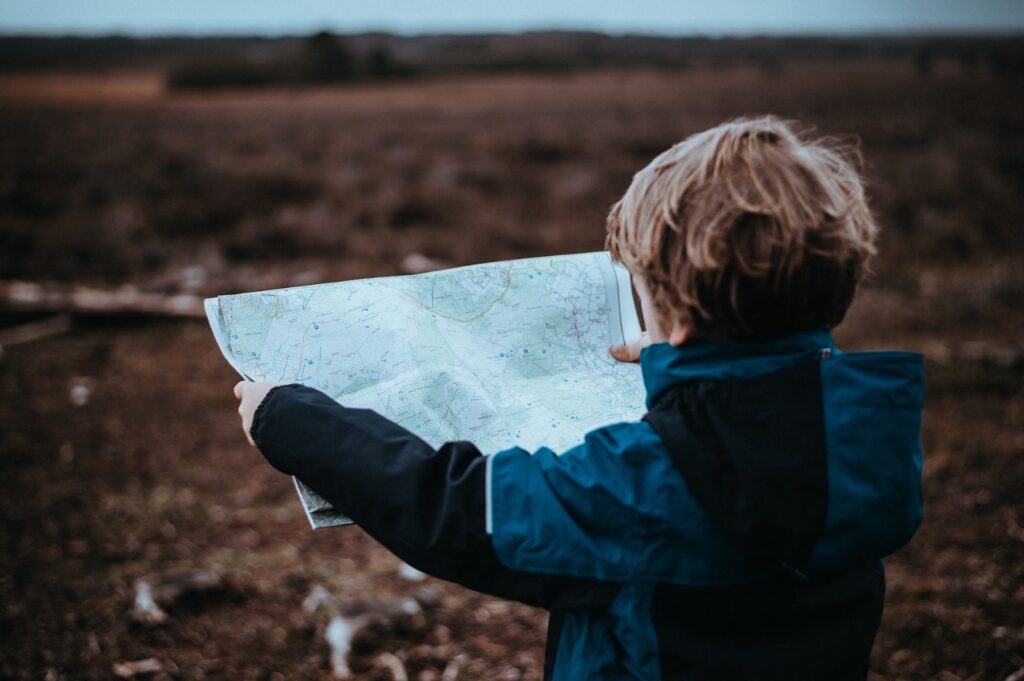 Kind bestudeert een landkaart om de juiste richting te bepalen